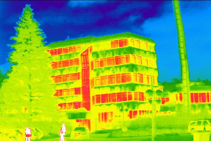Diese Thermografie eines Bürogebäudes zeigt rote gefärbte Fenster, die darauf hinweisen, dass hier viel Wärme nach außen abgegeben wird