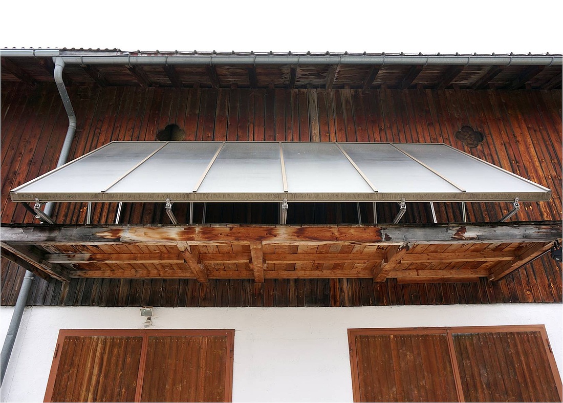 Schräg aufgeständerte Solarthermie-Großkollektoren an einer Hausfassade eines landwirtschaftlichen Betriebes in Österreich. (Foto: energie-experten.org)