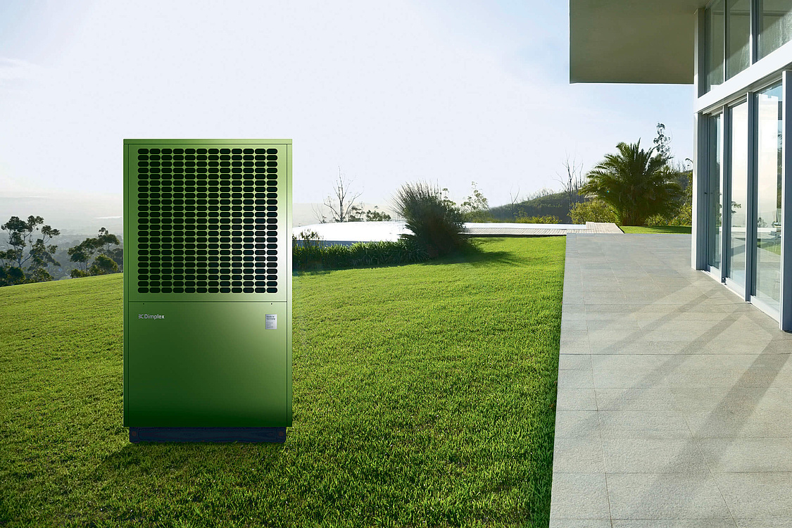 Dieses Bild zeigt eine grüne Luftwärmepumpe auf einem grünen Rasen