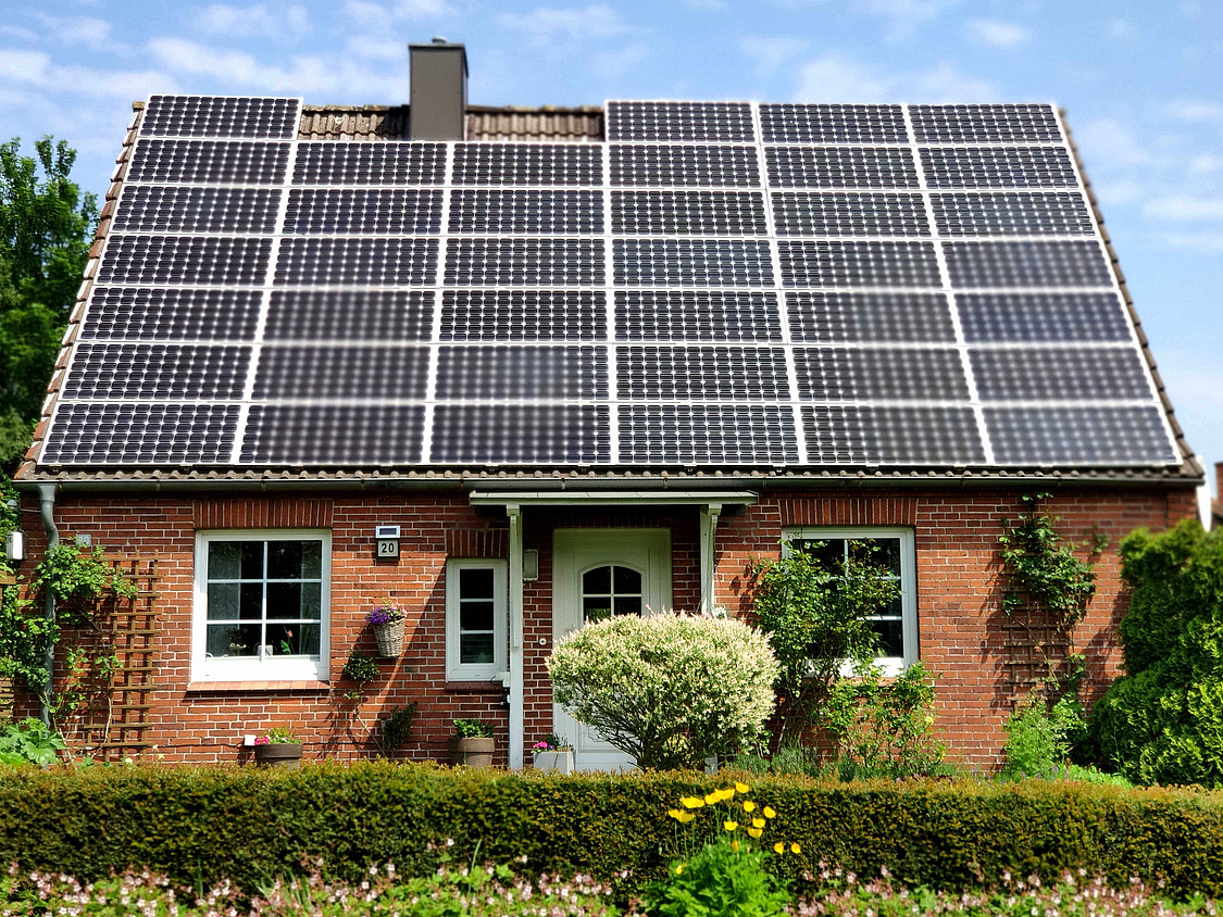 Dieses Bild zeigt ein Einfamilienhaus mit einer komplett mit Solarmodulen belegten Dachfläche