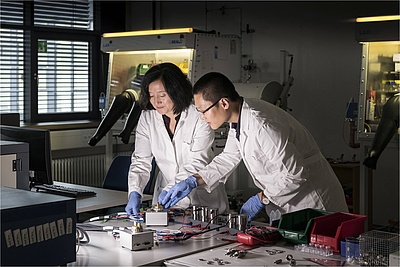 Zhirong Zhao-Karger (links) und Zhenyou Li (rechts) aus dem Exzellenzcluster POLiS (Post Lithium Storage Cluster of Excellence) gelang es, vielversprechende Elektrolyte für Calcium-Batterien herzustellen. (Foto: Markus Breig / KIT)