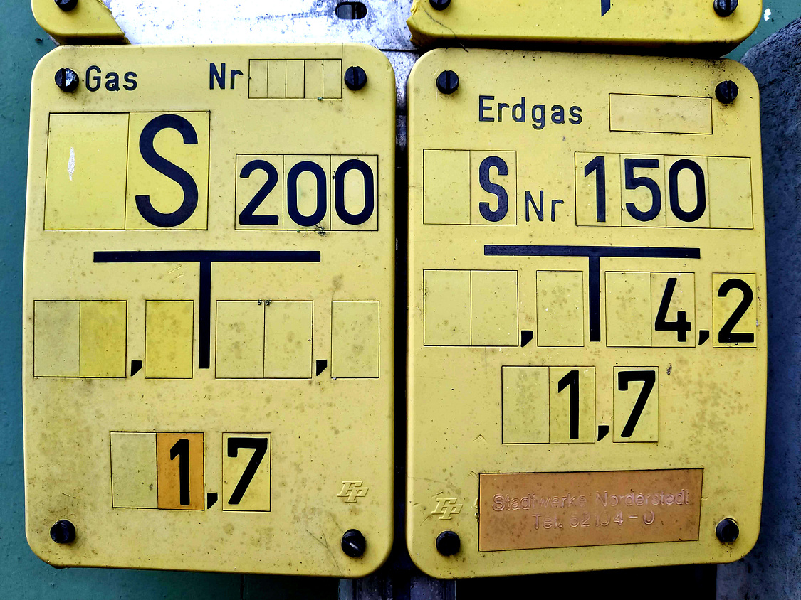 Dieses Foto zeigt zwei typische gelbe Schilder mit Informationen zum Gasanschluss
