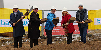 Hier sehen Sie 5 Personen beim offiziellen Spatenstich zum Bau des Sonnenhauses der Bayernwerk