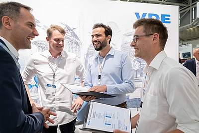 VDE vier Männer freuen sich bei Übergabe des Zertifikats