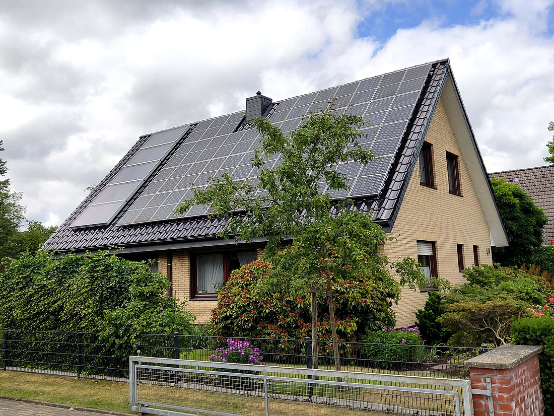 Auf diesem Bild sehen Sie ein Einfamilienhausdach, auf dem sowohl Solarmodule (rechts) zur Stromerzeugung als auch Solarkollektoren (links) zur Wärmeerzeugung installiert sind.
