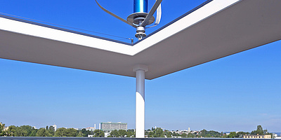 Das Bild zeigt eine Windkraftanlage auf dem Dach des Zentrums.