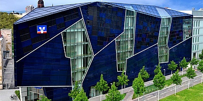 Das Gebäude zeigt das Volksbank-Gebäude mit der blauen Solar-Fassade von außen.