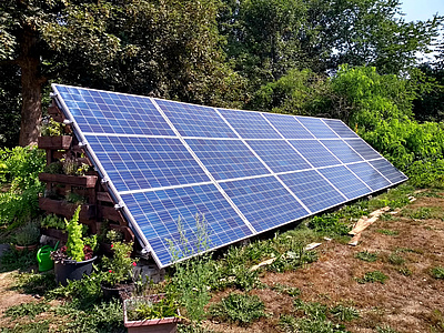 Auf diesem Foto sehen Sie eine selbstgebaute, in einem Garten aufgeständerte Solaranlage