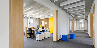 Das Bild zeigt einen Büroraum und Flur