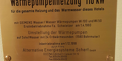 Das Bild zeigt ein Schild, welches über das Heizsystem mit Wärmepumpe informiert.