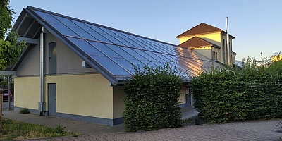 Blick auf einen Seitenflügel mit dachintegrierten Solarthermie-Kollektoren